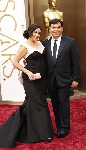 A woman and man in formal clothes on the Oscars red carpet