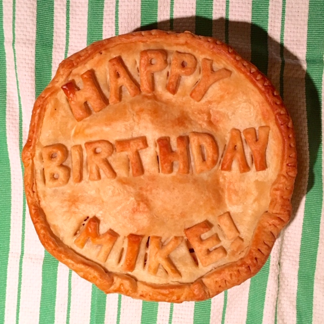 a double crust pie that says "Happy Birthday Mike!" with pie crust