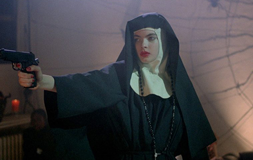 Zoë Tamerlis in the film 'Ms .45' dressed in a nun habit pointing a gun
