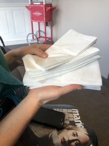 two hands holding a stack of napkins