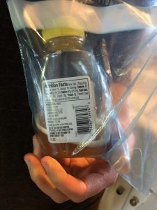 a jar of honey mixed with vinegar inside a ziploc bag