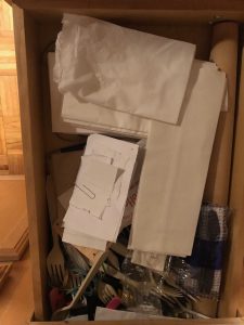 mismatched napkins and plastic utensils in a kitchen drawer