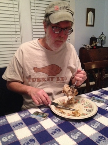 a man wearing a t-shirt that says Turkey Leg while eating turkey