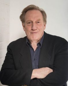 Adult Alan Zweibel in color wearing a blazer and button up shirt 