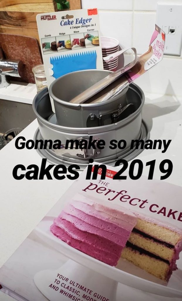 a mixing bowl, cake pan, and cookbook on a counter with the caption 