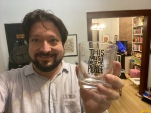 Dan McCoy in his apartment holding a Talking Heads glass.