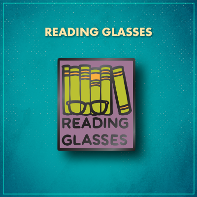 Reading Glasses. A purple rectangle with five green books standing straight on a shelf with a sixth green book to the right that is leaning on the book to its left. Black glasses sit in front of the books and words "Reading Glasses" are in black on the bottom of the pin.