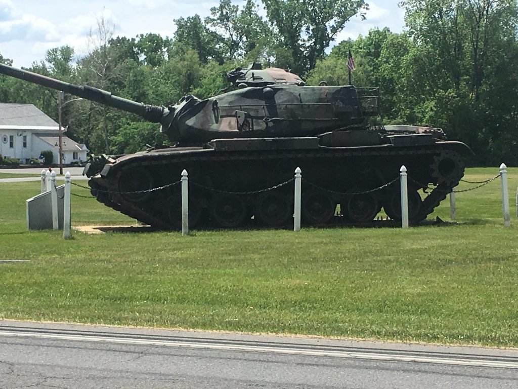 a Sherman tank on display on a large lawn