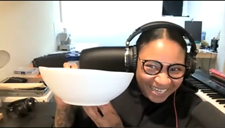 Guest Bailiff Jean Grae, photographed during the Zoom recording, smiling and holding a white shallow bowl