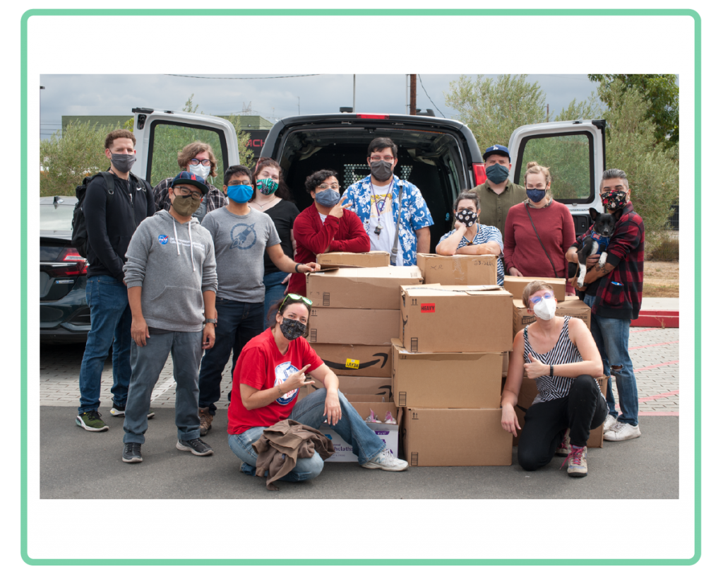 a photo of maxfun staff surrounding piles of boxes of care kits