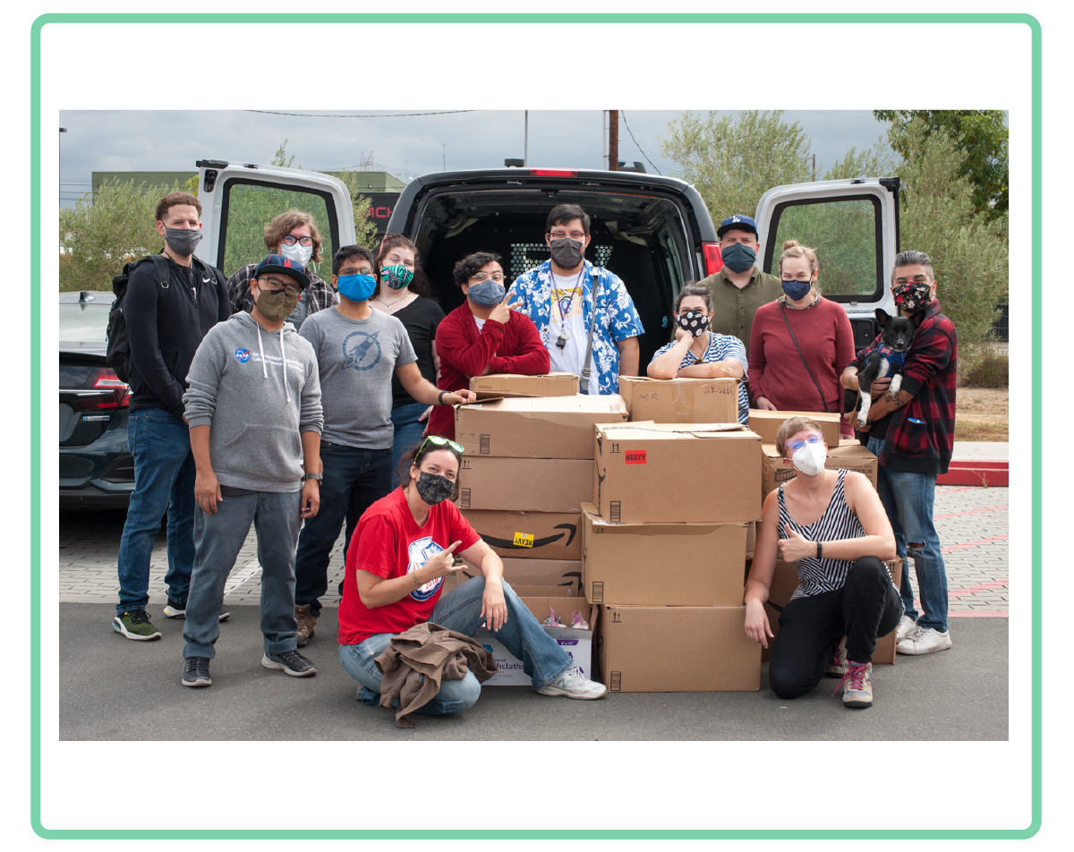 a photo of maxfun staff surrounding piles of boxes of care kits