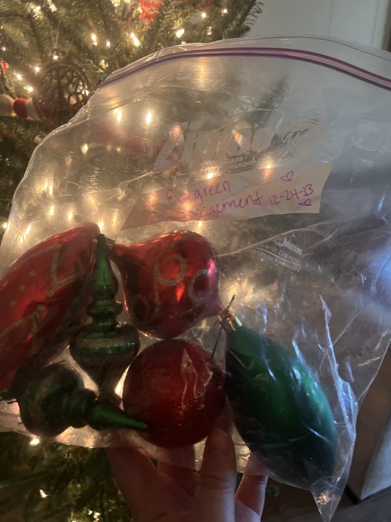 A large ziploc bag of green and red tree ornaments. Written on the bag is 