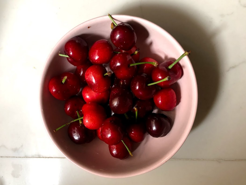 A pink bowl of cherries