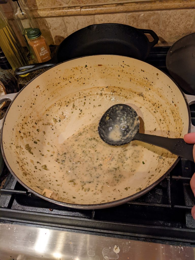 A Le Creuset pot that has a layer of leftover food covering the inside
