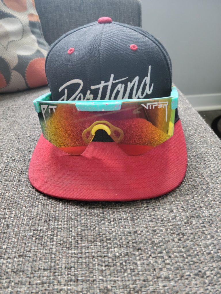 A baseball cap with reflective Viper brand sunglasses resting on the brim