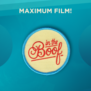 Maximum Film! A round patch with a blue border and light yellow background and the words “in the Boof” written in curly lettering.