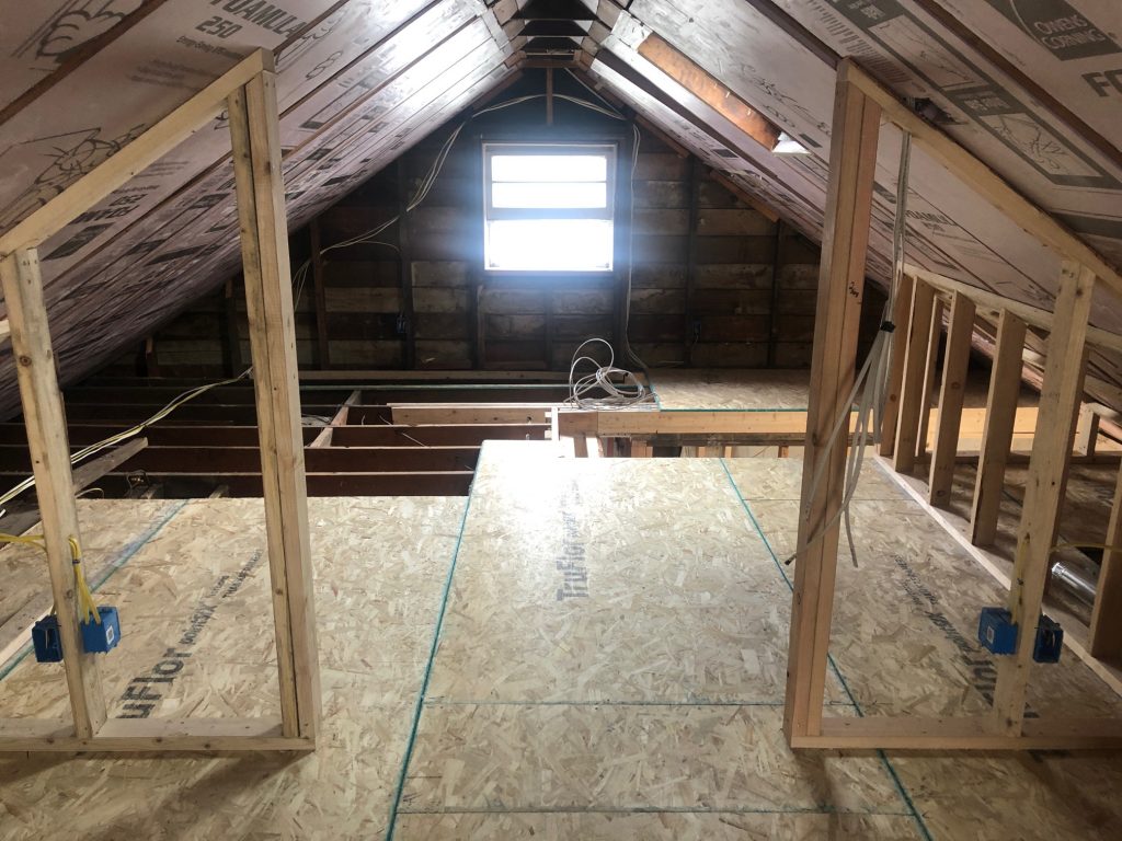 An attic space in the process of remodeling, with studs and boards on the floor