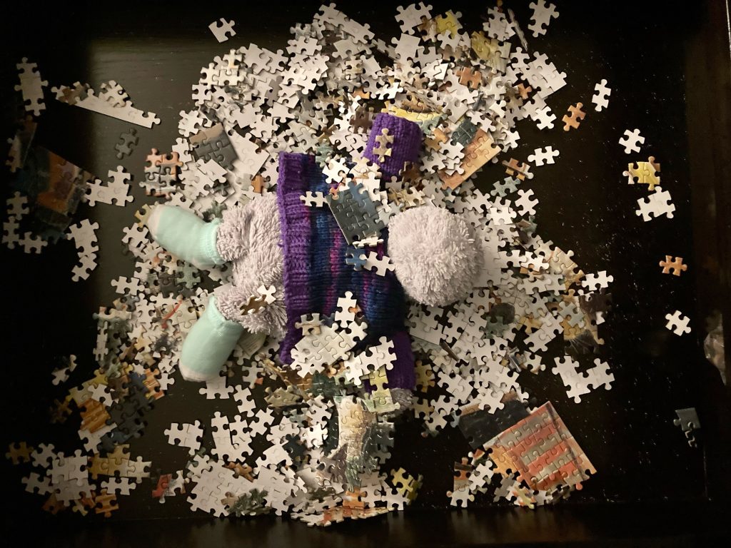 a stuffed hippo buried in puzzle pieces