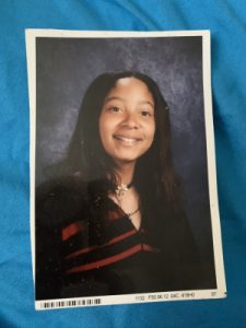 Ashley Ray in her high school yearbook photo. She's wearing a black pullover jacket. 