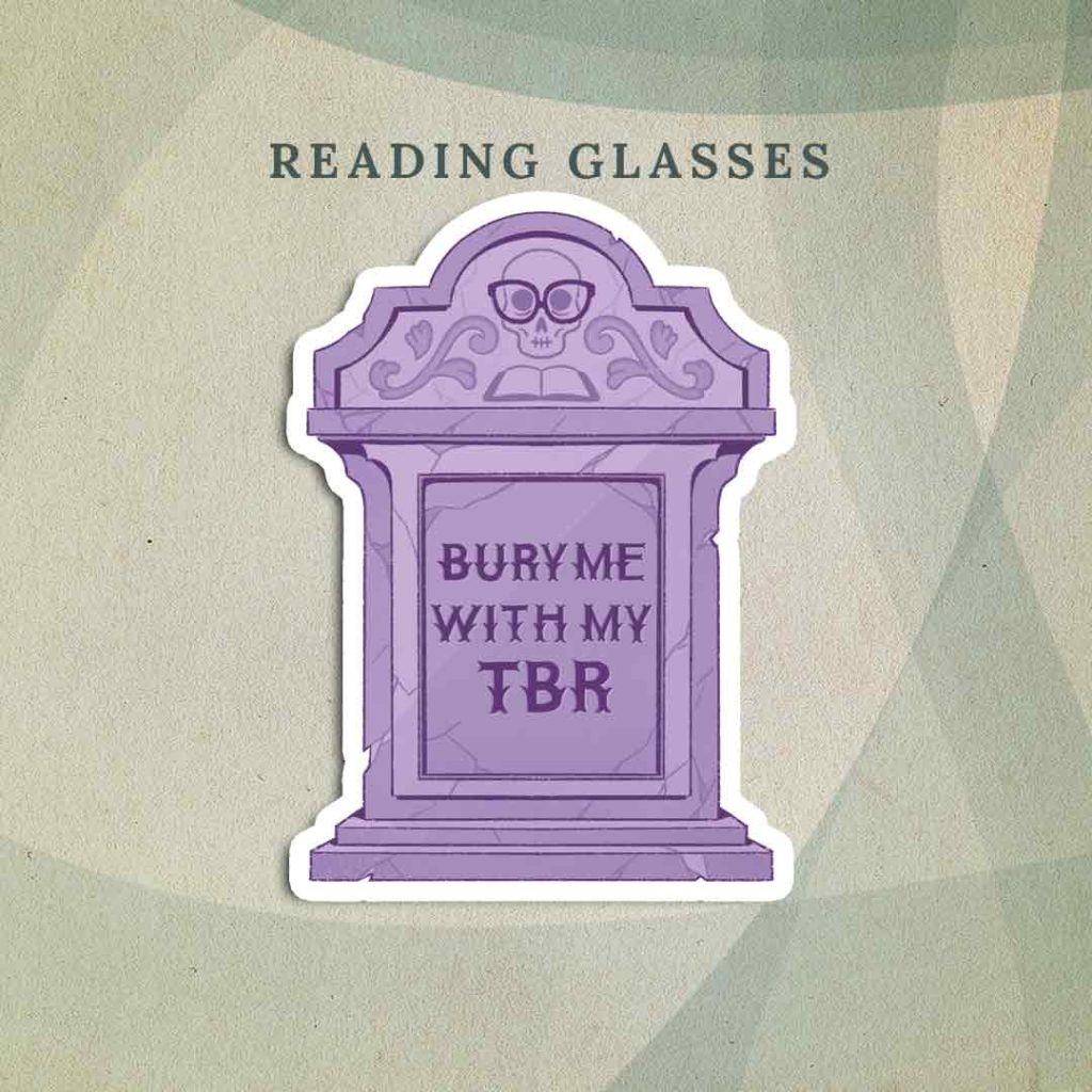 Reading Glasses: A purple tombstone that has “Bury me with my TBR” inscribed on the front where the name and dates would typically be. The top of the headstone has an illustration of a skull wearing glasses placed above an open book.