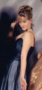 Christine Weatherup in a prom photo. She's wearing a blue dress and her blonde hair is in a very fancy up-do