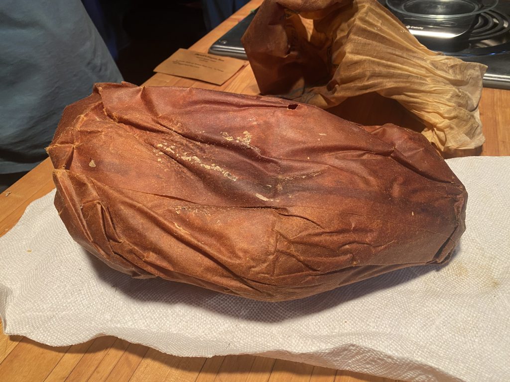 a very old, greasy cured ham wrapped in waxed paper