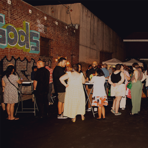 A group of people standing outside at night during a party