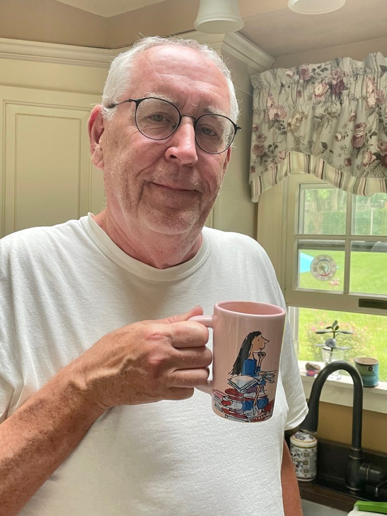 A man holding a Matilda: The Musical coffee mug