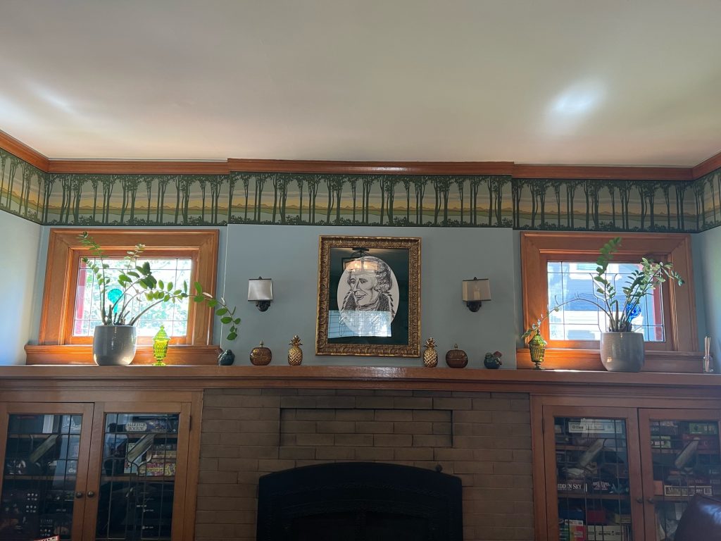 An illustration of Alexander Hamilton hanging above a built in cabinet full of board games