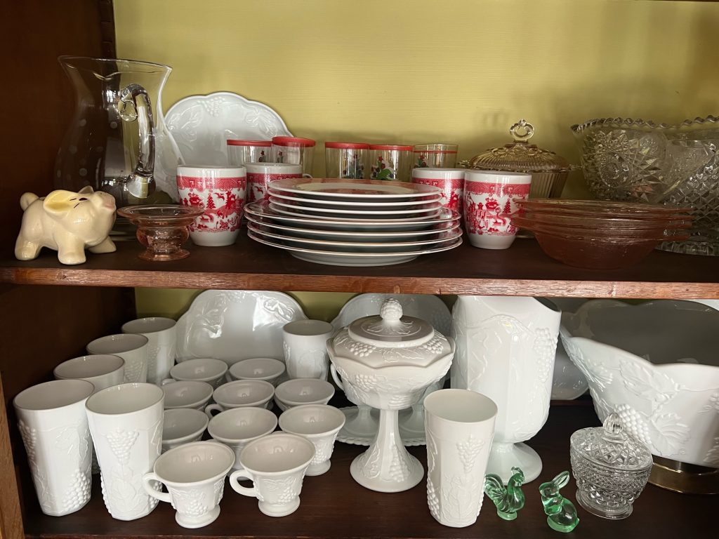 several milk glass pieces on display in a china cabinet