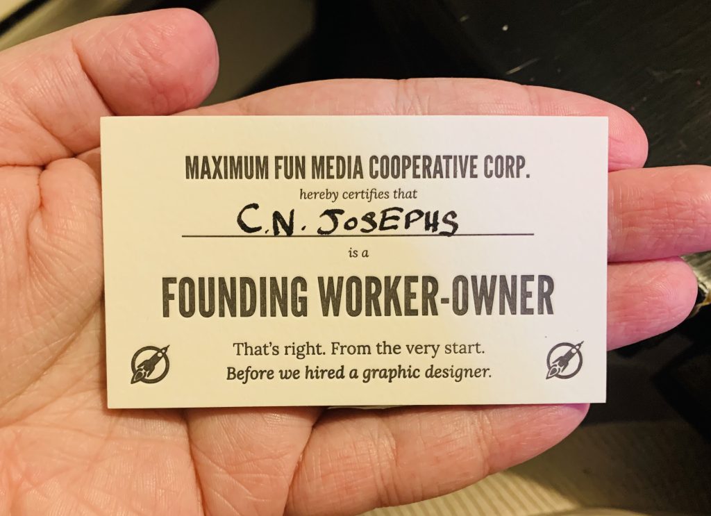 A business card-sized paper card that says "Maximum Fun Media Cooperative Corp. hereby certifies that C.N. Josephs is a founding worker-owner. That's right. From the very start. Before we hired a graphic designer."