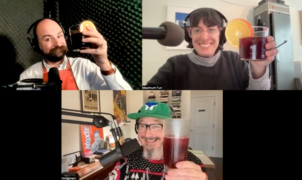 A zoom screenshot with three people holding up a glass of a burgundy drink