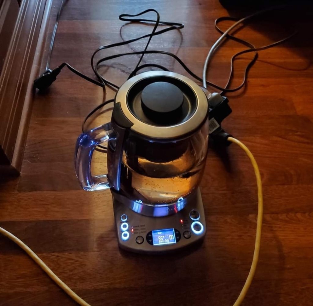 An electric teapot with a bunch of cords sticking out and around it