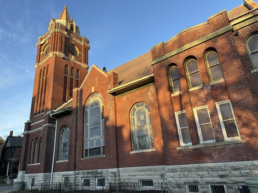 A large, brick building with huge windows and a steeple