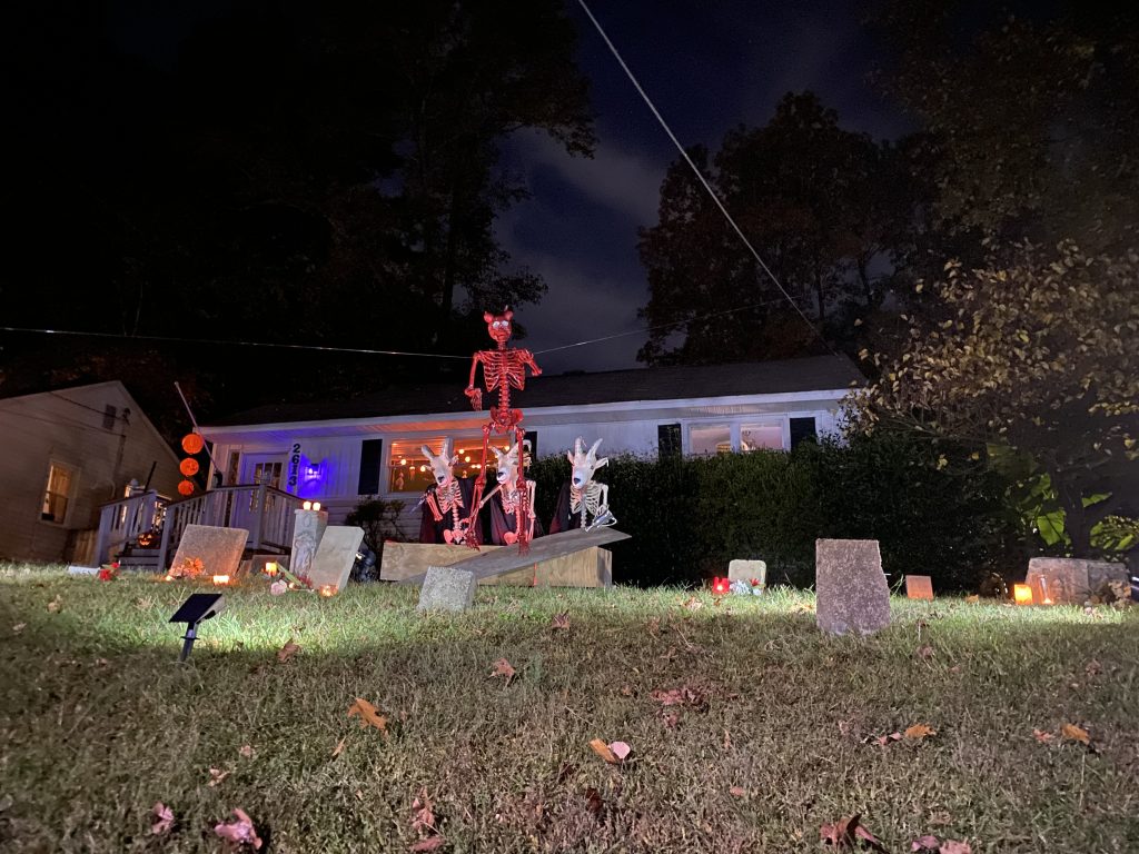 Halloween decor on a front lawn at night