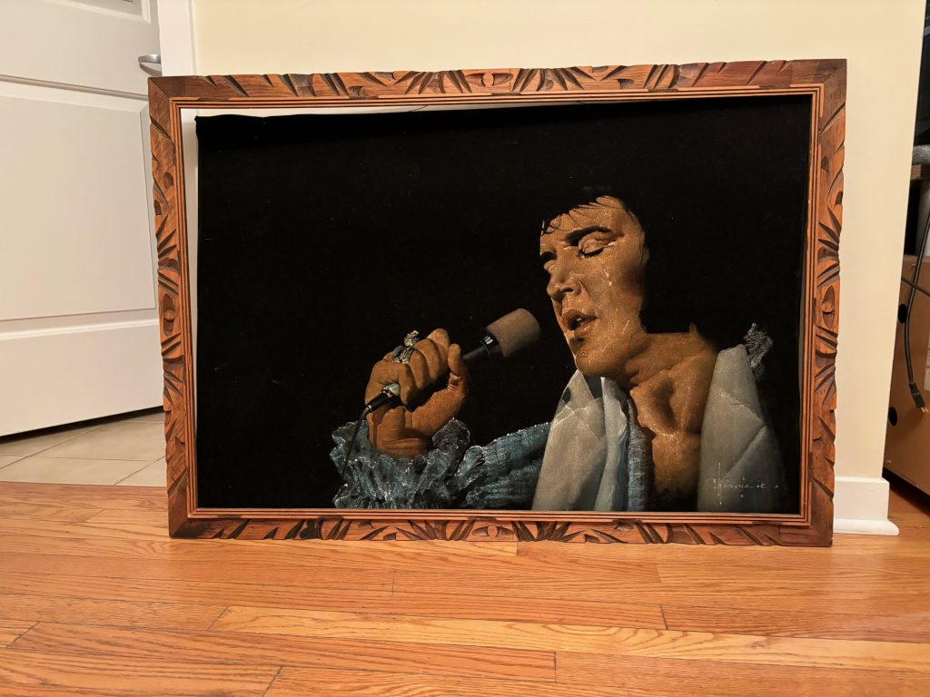 A framed Elvis Presley painted on black velvet