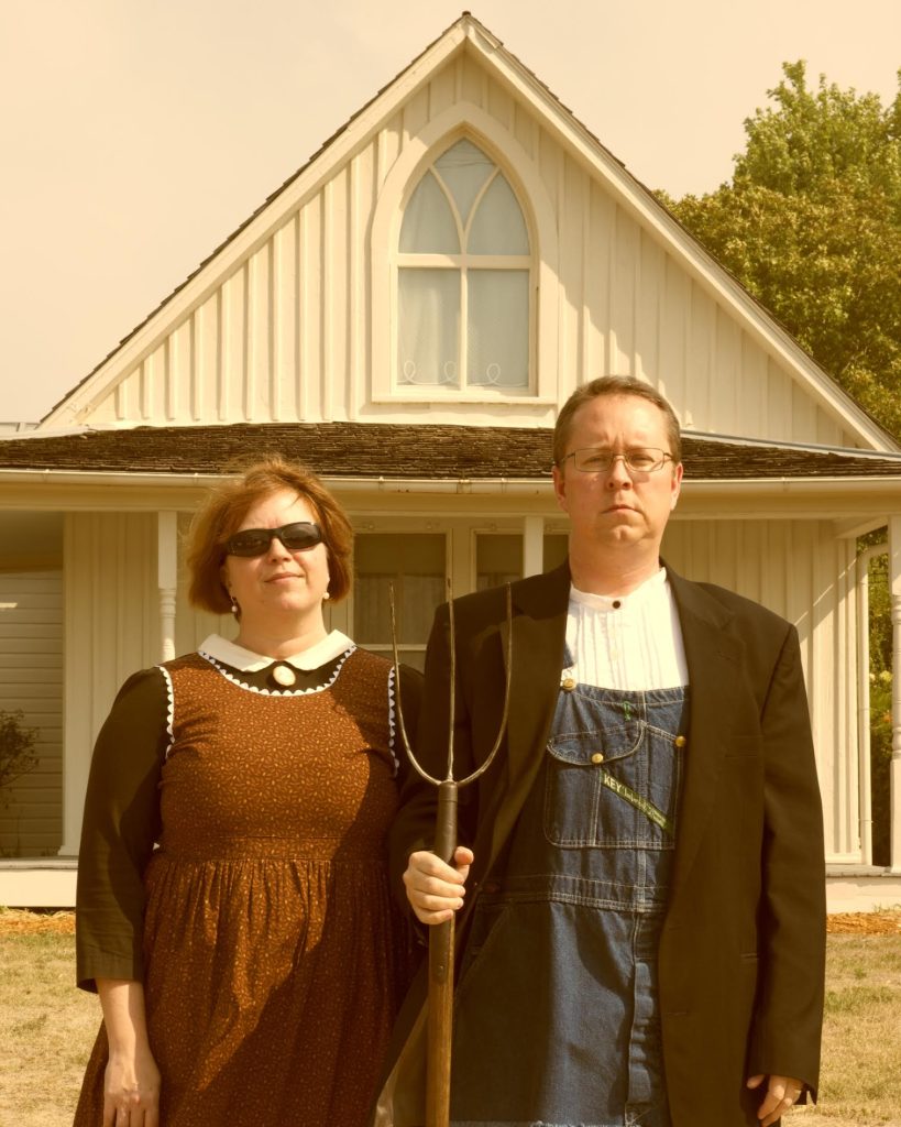 A couple standing in front of the home from the painting 