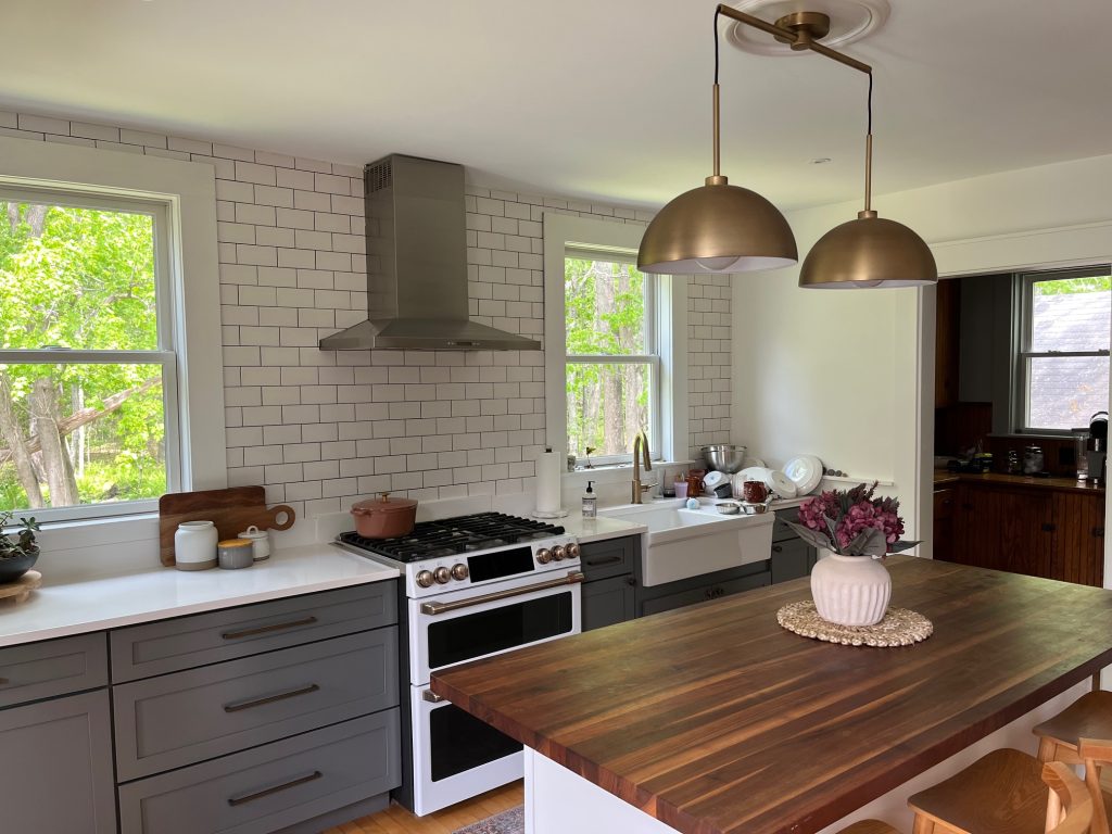 Another angle of the same kitchen with a view out the windows of trees