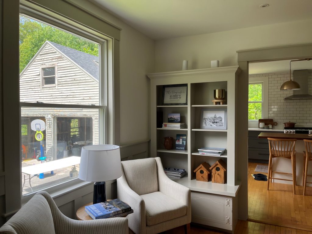 A small room off a kitchen with a window and a garage visible outside