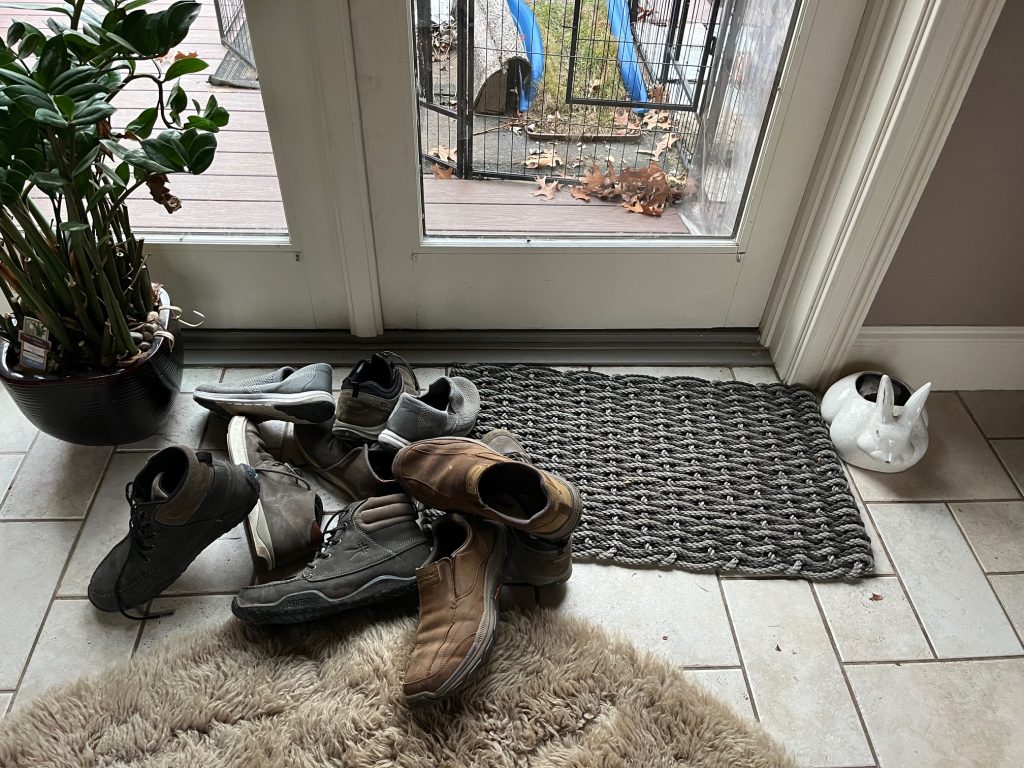 a few pairs of shoes next to a door inside a home