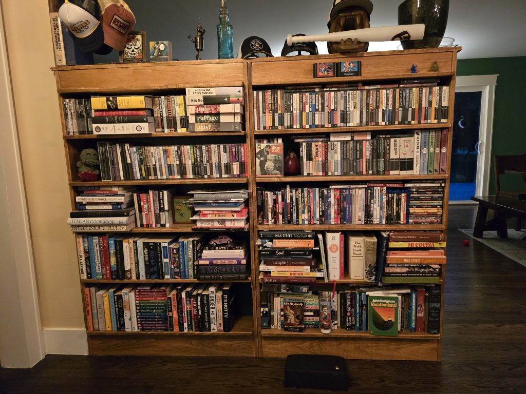Two large bookcases full mostly of DVDs and some books.