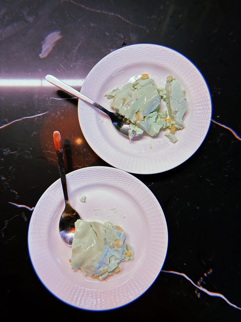 Two white plates with servings of a light green jello dish on them.