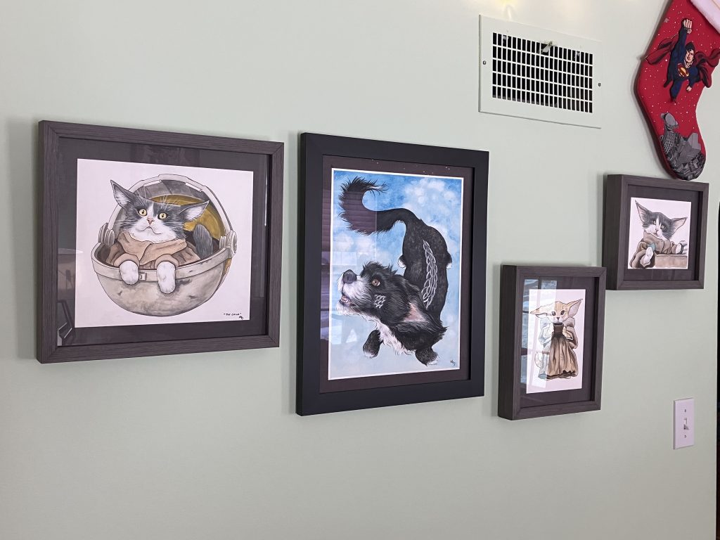 a few framed art pieces depicting pets