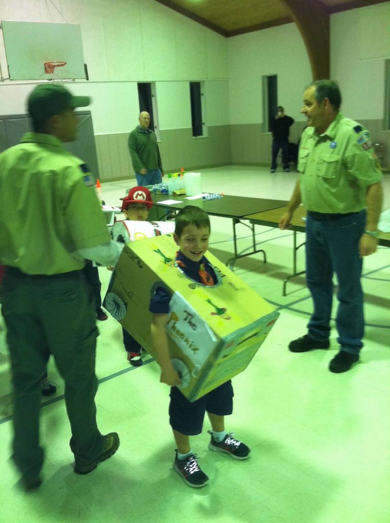 a child wearing a cardboard box decorated to be on theme with The Phoenix from X-Men