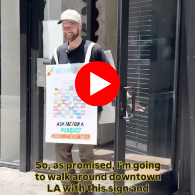 Richard exiting a door to the street wearing a sandwich board