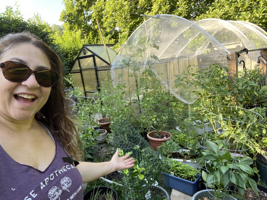 A woman standing in front of a home garden