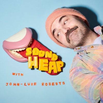 The logo for Sound Heap, featuring John Luke-Roberts looking over his shoulder at a model set of teeth with the tongue sticking out; the words "Sound Heap" sit on top of the tongue.