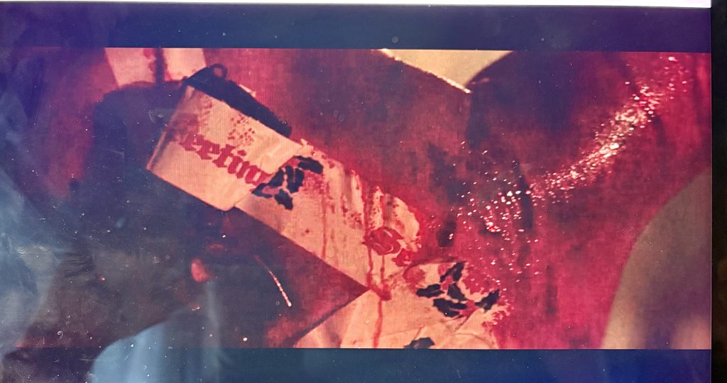 A scene from Die Hard showing John McClane's bloody back with a gun taped to it with 