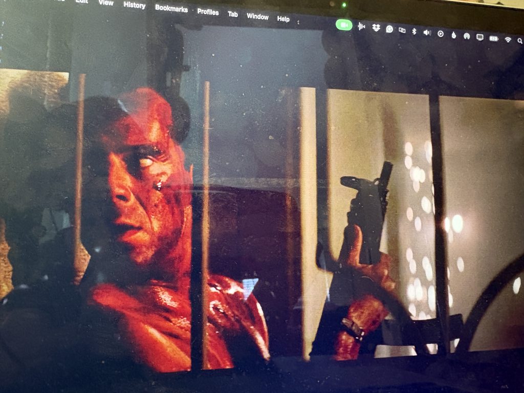 A scene fro DIE HARD showing John McClane looking bloody